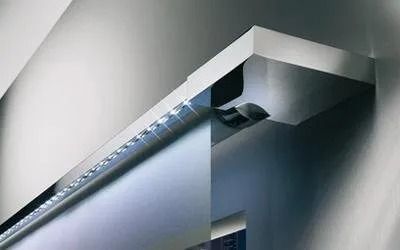 Primo piano di un moderno apparecchio di illuminazione da incasso installato vicino al bordo del soffitto