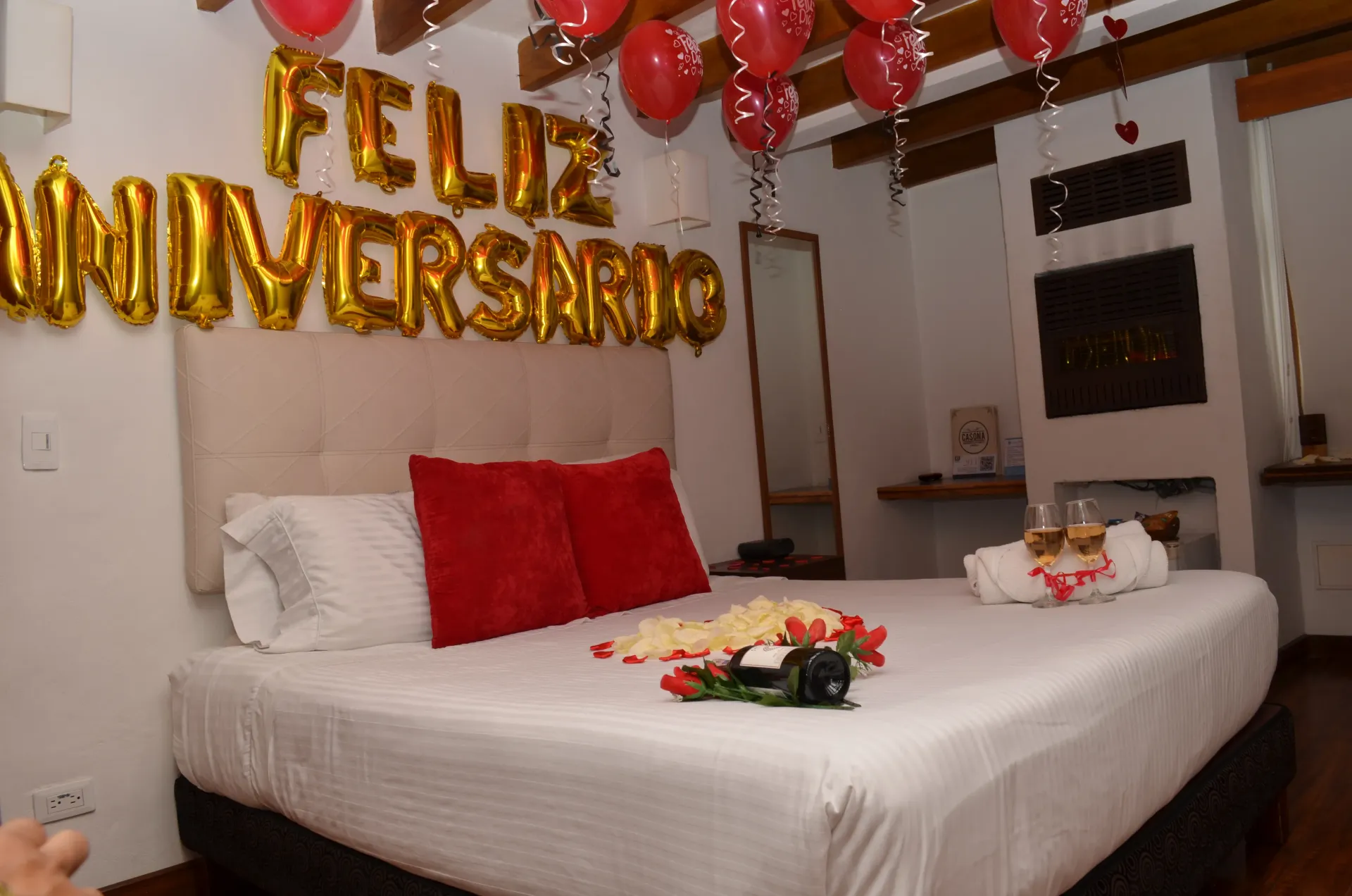 Dormitorio decorado para aniversario con globos, cartel de