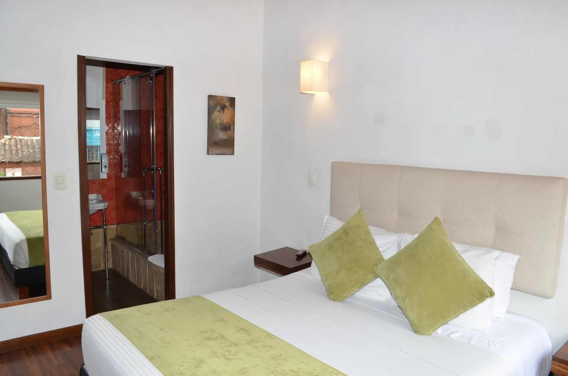 Bedroom with a bed, two pillows, and a doorway to a bathroom.