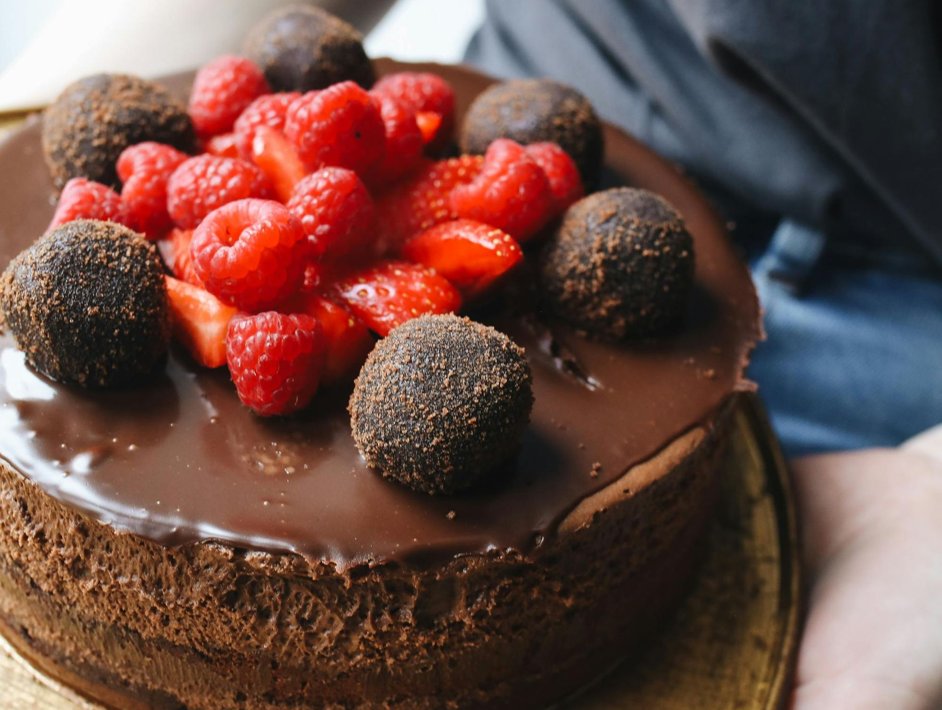 Pastel de chocolate cubierto con ganache, frutos rojos frescos y trufas de chocolate.