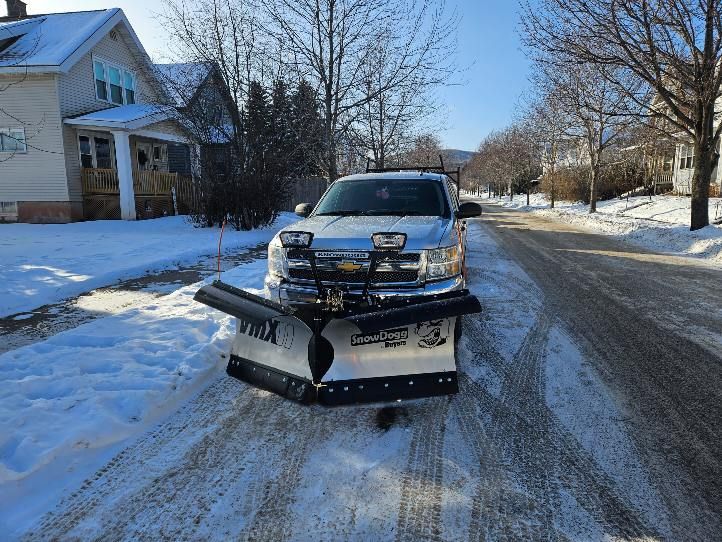 A snow plow is parked on the side of the road.