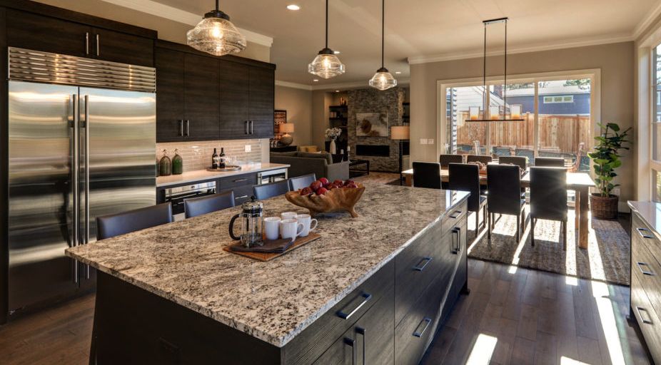 A kitchen with granite counter tops and stainless steel appliances.