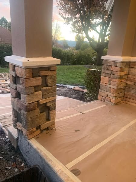 A stone pillar is sitting on the side of a porch.