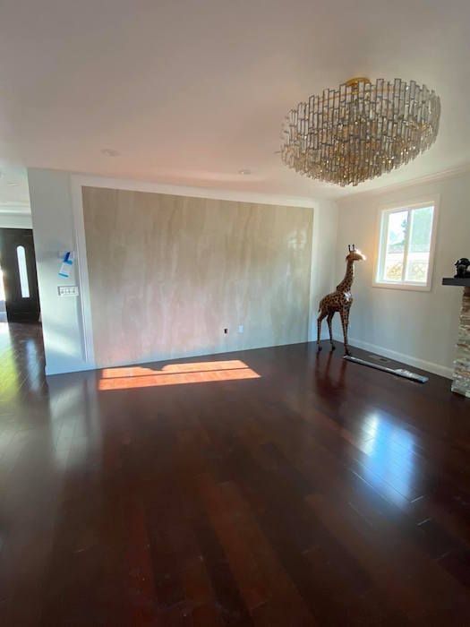A living room with a giraffe statue and a chandelier.