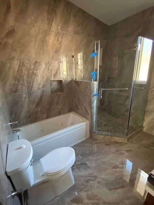 A bathroom with a toilet , tub , shower and sink.