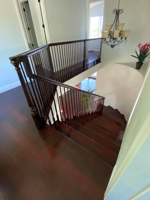 A wooden staircase with a chandelier hanging from the ceiling