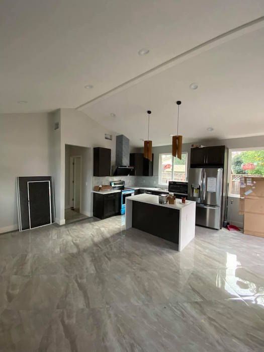 A kitchen with stainless steel appliances and a large island in the middle of the room.