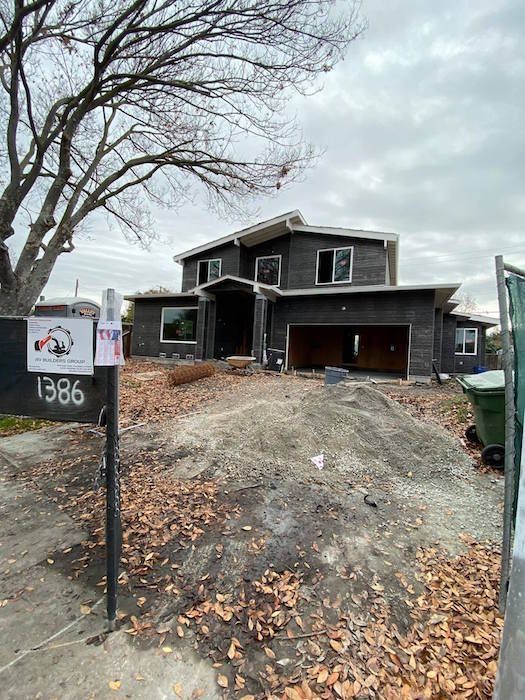 A large house under construction with a mailbox in front of it.