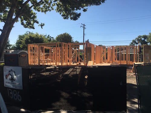 A large wooden structure is being built on a construction site.