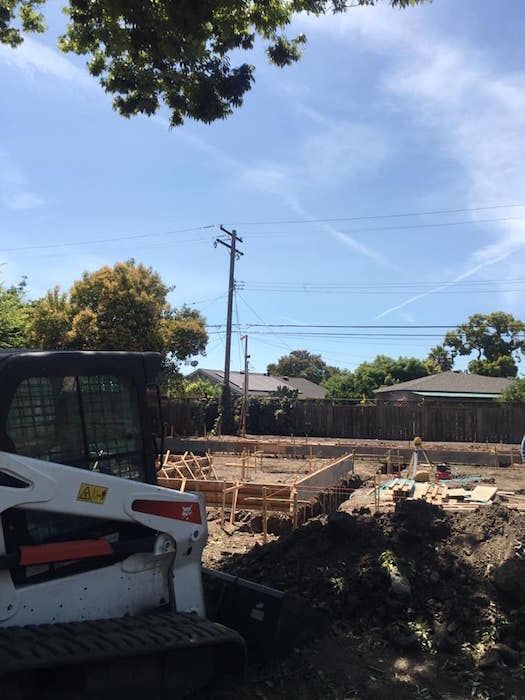 A bobcat is parked in front of a construction site