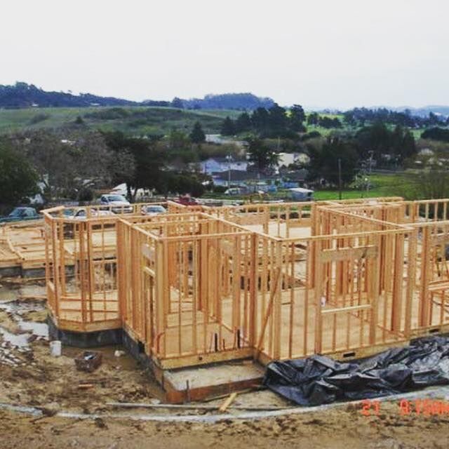 A house is being built in the middle of a dirt field