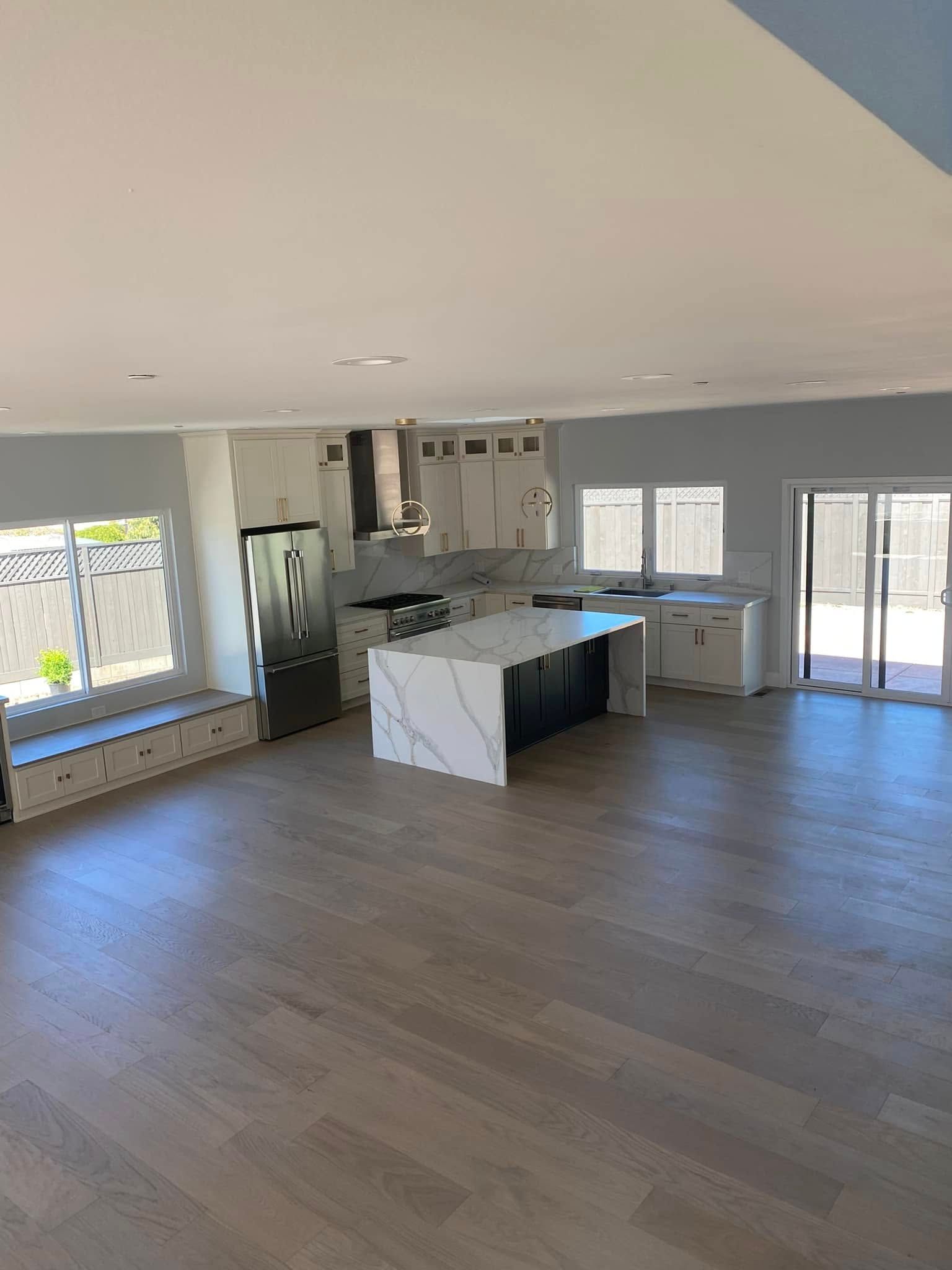 A large empty kitchen with a large island in the middle of the room.
