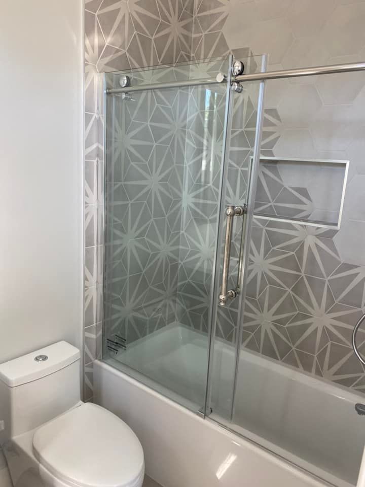 A bathroom with a toilet , tub , shower and sliding glass door.