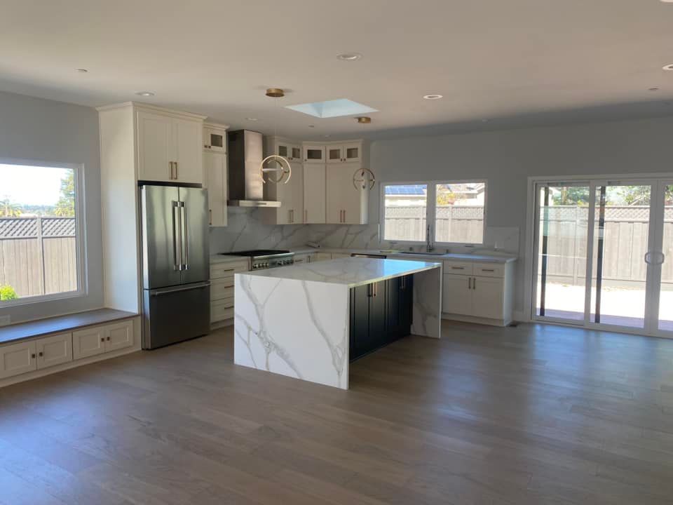 A kitchen with stainless steel appliances and a large island in the middle of the room.