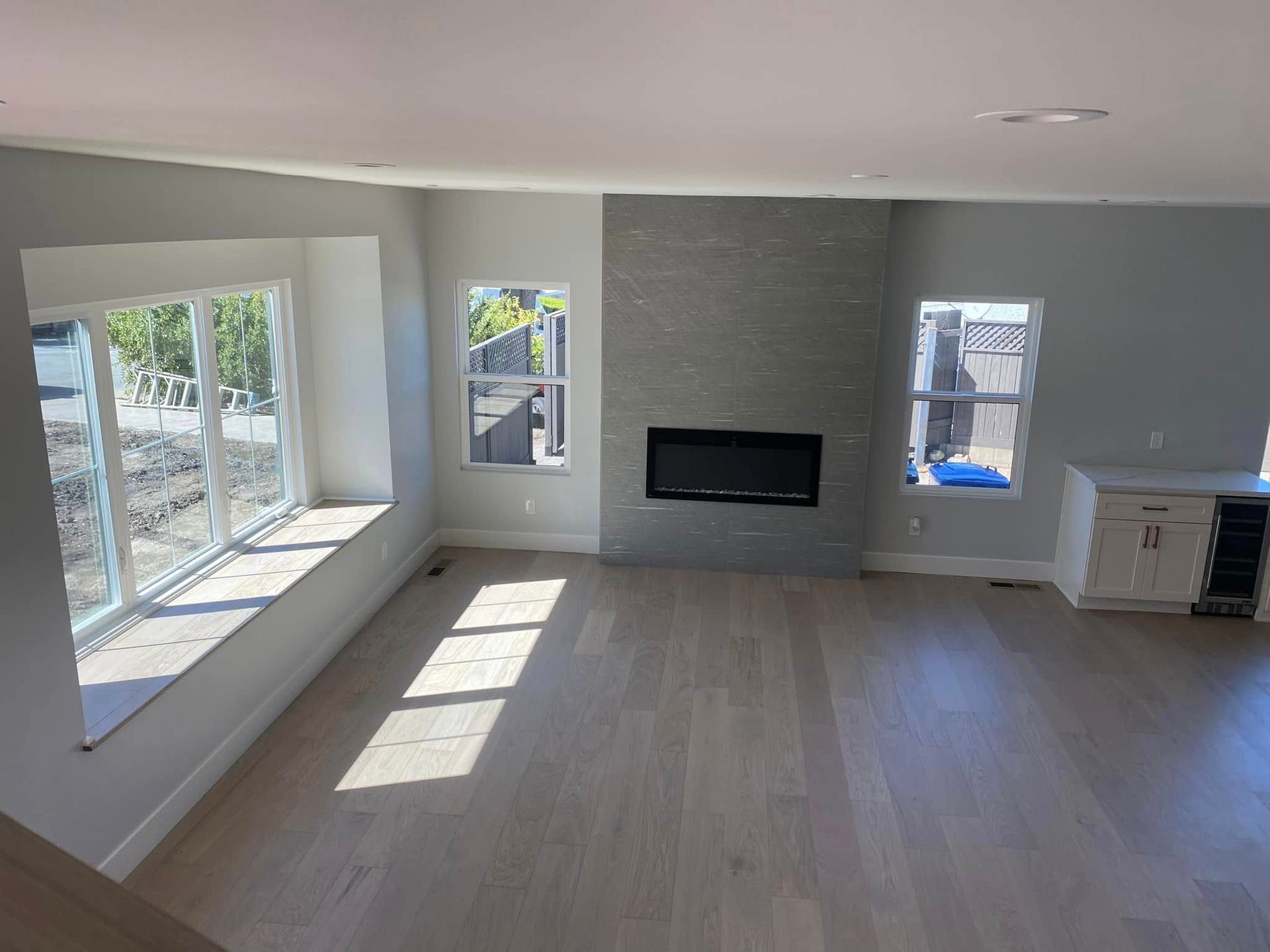 An empty living room with a fireplace and windows.