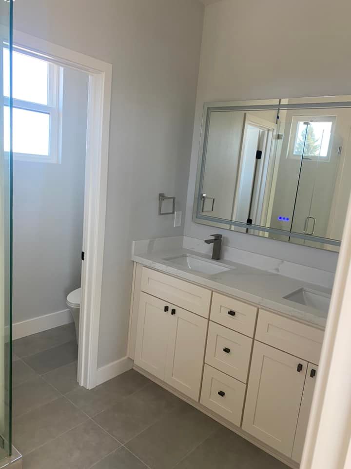A bathroom with a sink , mirror and toilet.