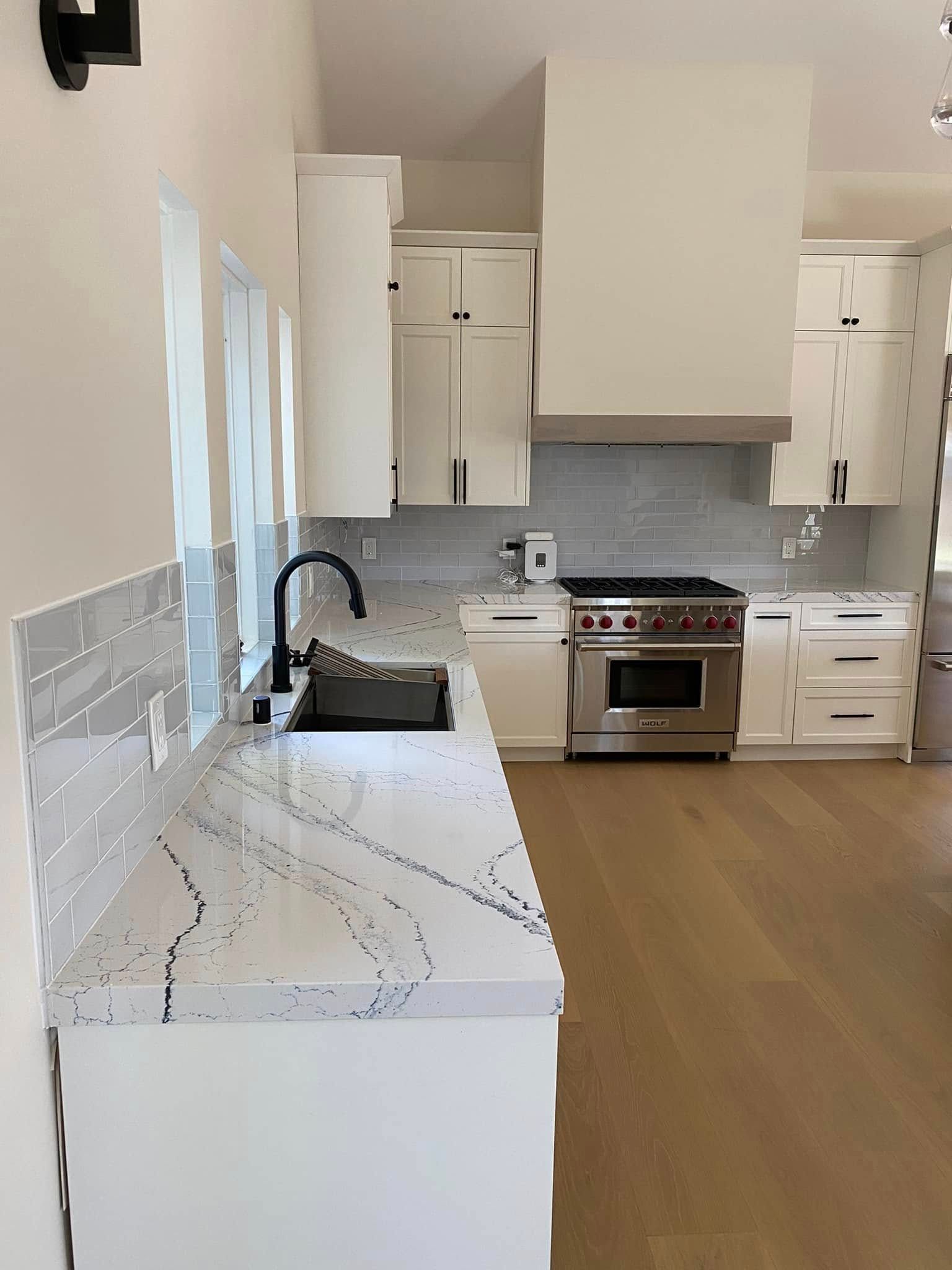 A kitchen with white cabinets and stainless steel appliances