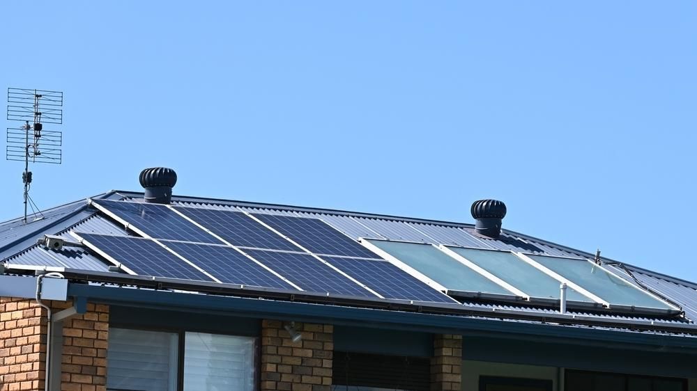 A House With Solar Panels on the Roof and an Antenna — Power & Data Support Services In Tully, QLD
