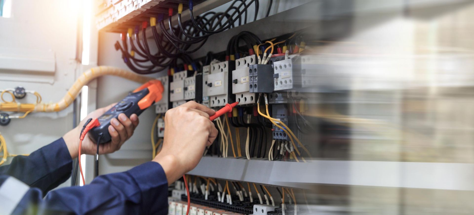 An Electrician is Working on an Electrical Panel With a Screwdriver — Power & Data Support Services In Cardwell, QLD