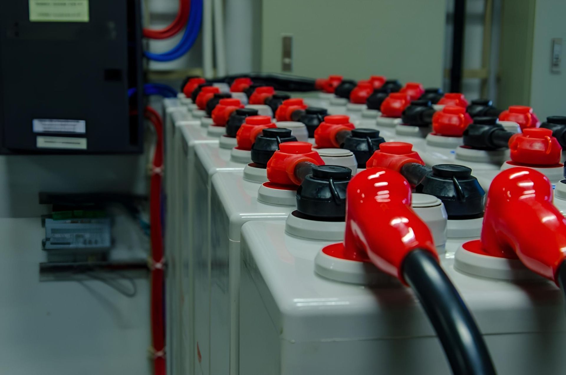 A Row of Batteries With Red Caps and Black Wires — Power & Data Support Services In Mapoon, QLD