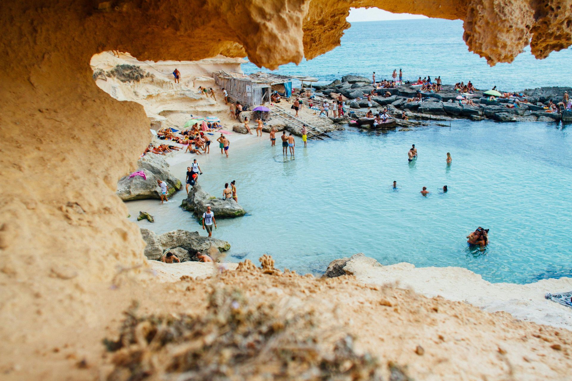 A group of people are swimming in the ocean on a beach.