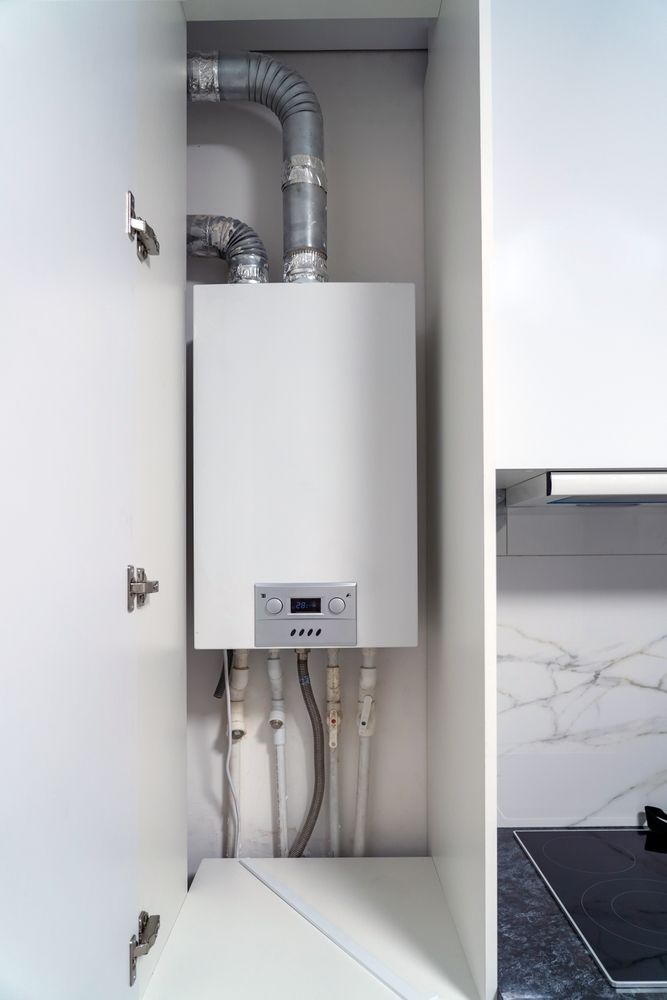 A gas boiler is built into a cabinet in a kitchen.