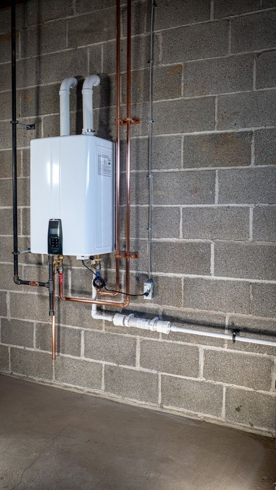 A water heater is mounted to a brick wall in a basement.