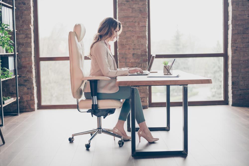 A Woman Is Sitting At A Desk — Shop Fittings Office Furniture Materials Handling In Gosford, NSW