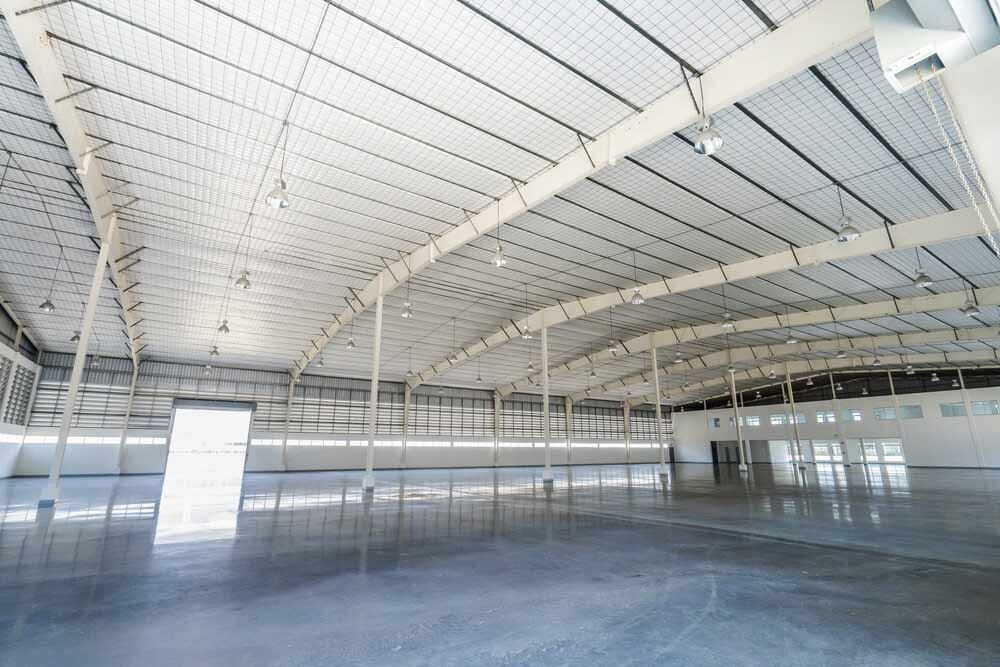 A Large Empty Warehouse With A White Roof — Shop Fittings Office Furniture Materials Handling In Gosford, NSW