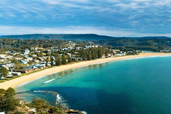 An Aerial View Of A Beach With Mountains In The Background — Shop Fittings Office Furniture Materials Handling In Central Coast, NSW