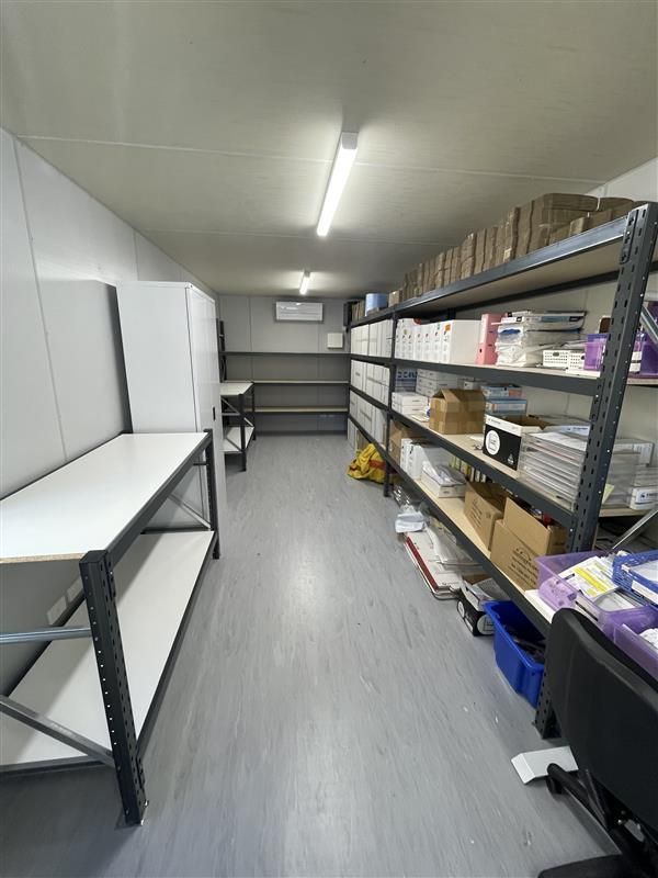 A Man Is Driving A Forklift In A Warehouse — Shop Fittings Office Furniture Materials Handling In Gosford, NSW