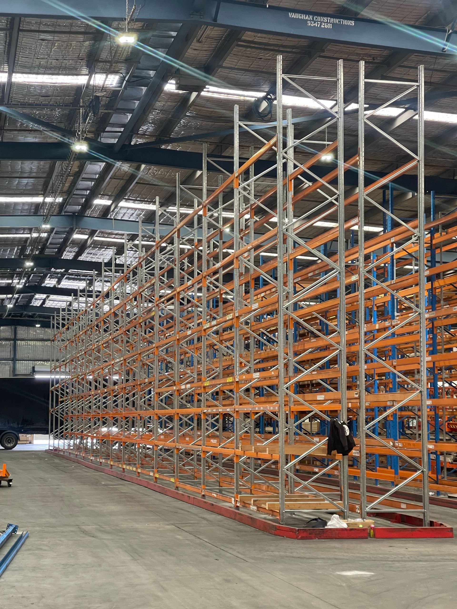 A Man Is Pushing A Pallet Truck In A Warehouse — Shop Fittings Office Furniture Materials Handling In Gosford, NSW