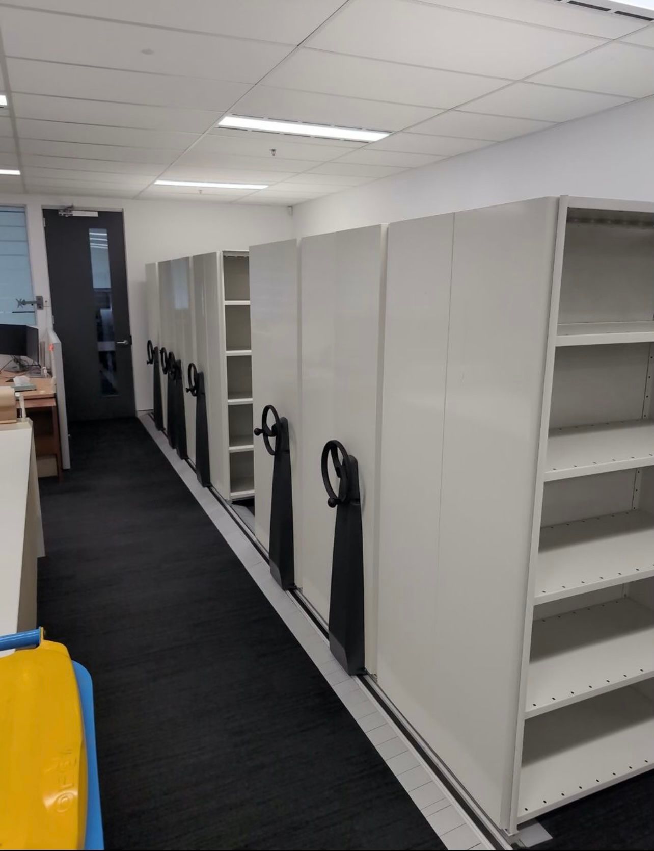 A Blue Scissor Lift Is Parked In Warehouse — Shop Fittings Office Furniture Materials Handling In Gosford, NSW