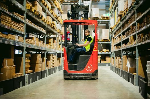 A Man Is Driving A Forklift In A Warehouse — Shop Fittings Office Furniture Materials Handling In Gosford, NSW