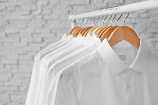 A Row Of White Shirts Hanging On A Rack — Shop Fittings Office Furniture Materials Handling In Gosford, NSW