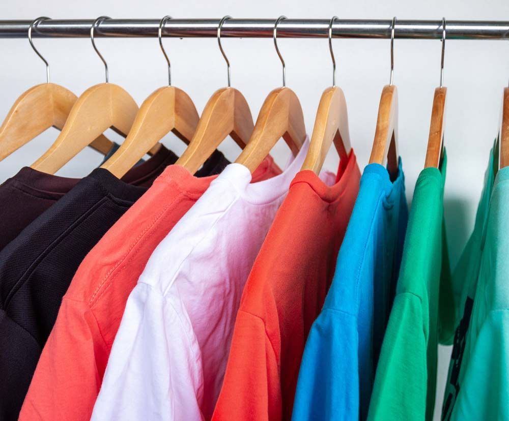 A Row Of Colourful Shirts Are Hanging — Shop Fittings Office Furniture Materials Handling In Silverwater, NSW
