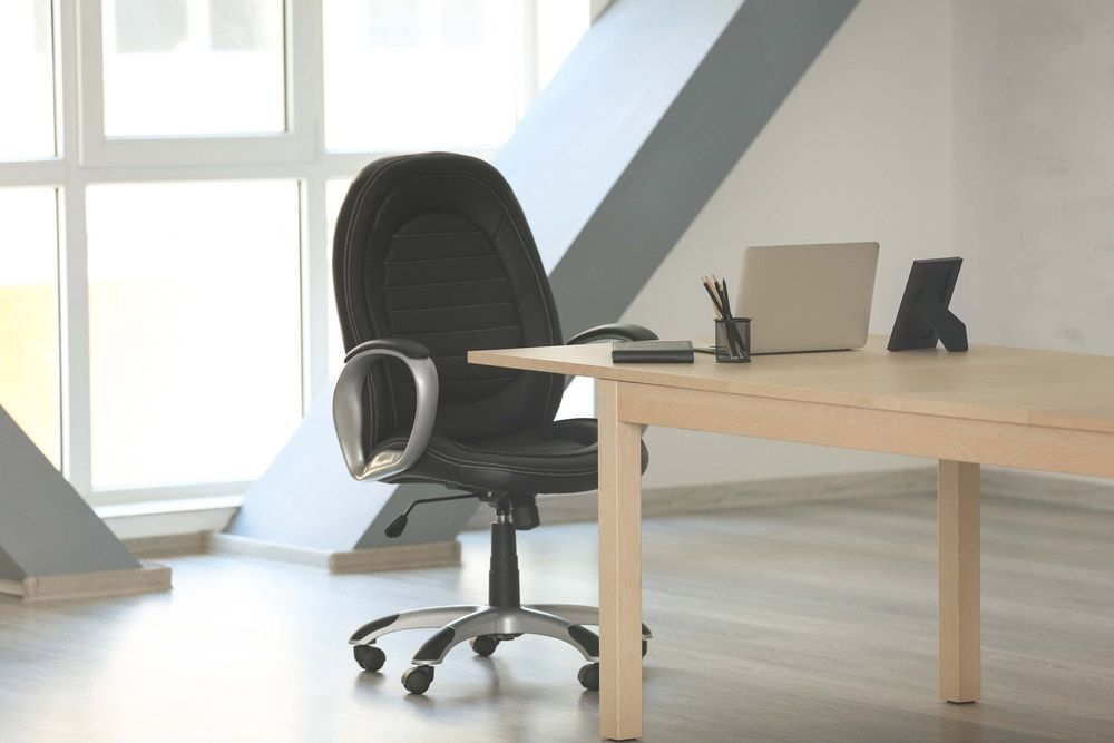 An Office Chair Is Sitting At A Desk — Shop Fittings Office Furniture Materials Handling In Macquarie Park, NSW