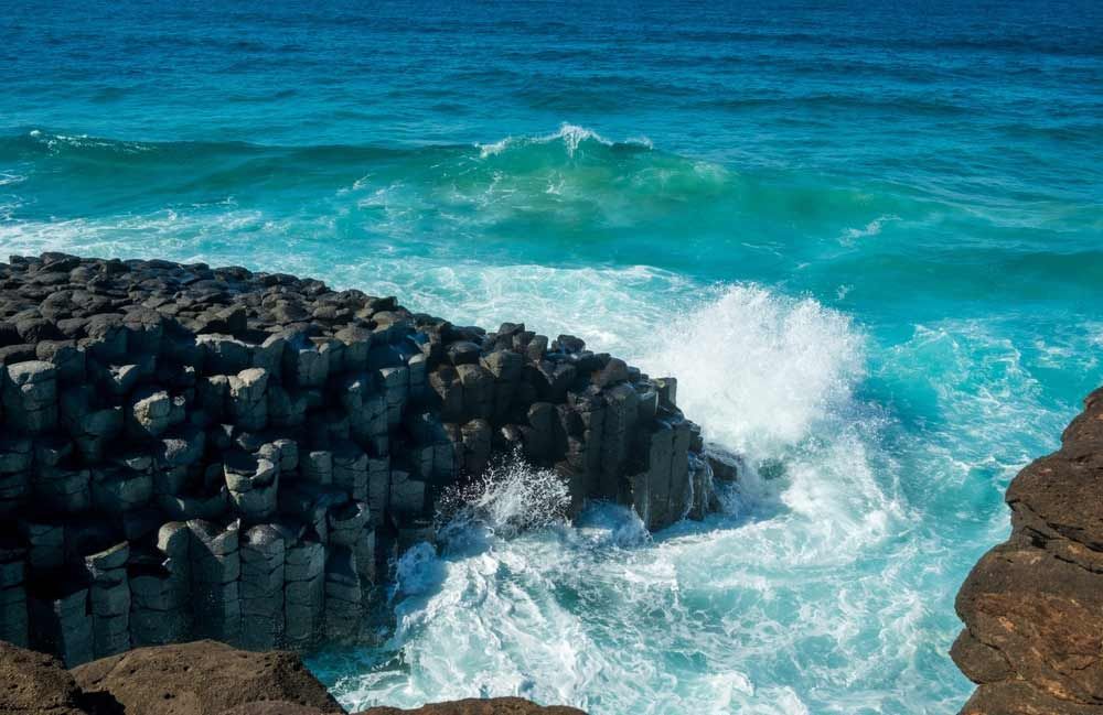 Waves Crashing Against A Rock Formation In The Ocean — Shop Fittings Office Furniture Materials Handling In Marrickville, NSW