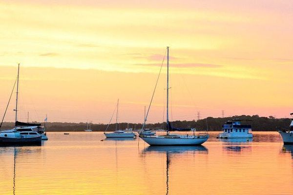 A Group Of Sailboats Are Docked In A Harbor At Sunset — Shop Fittings Office Furniture Materials Handling In Macquarie Park, NSW