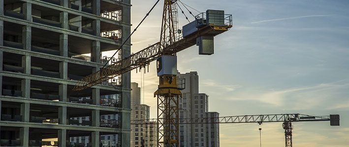 A construction site with cranes and a building under construction.