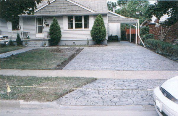 A white car is parked in front of a house