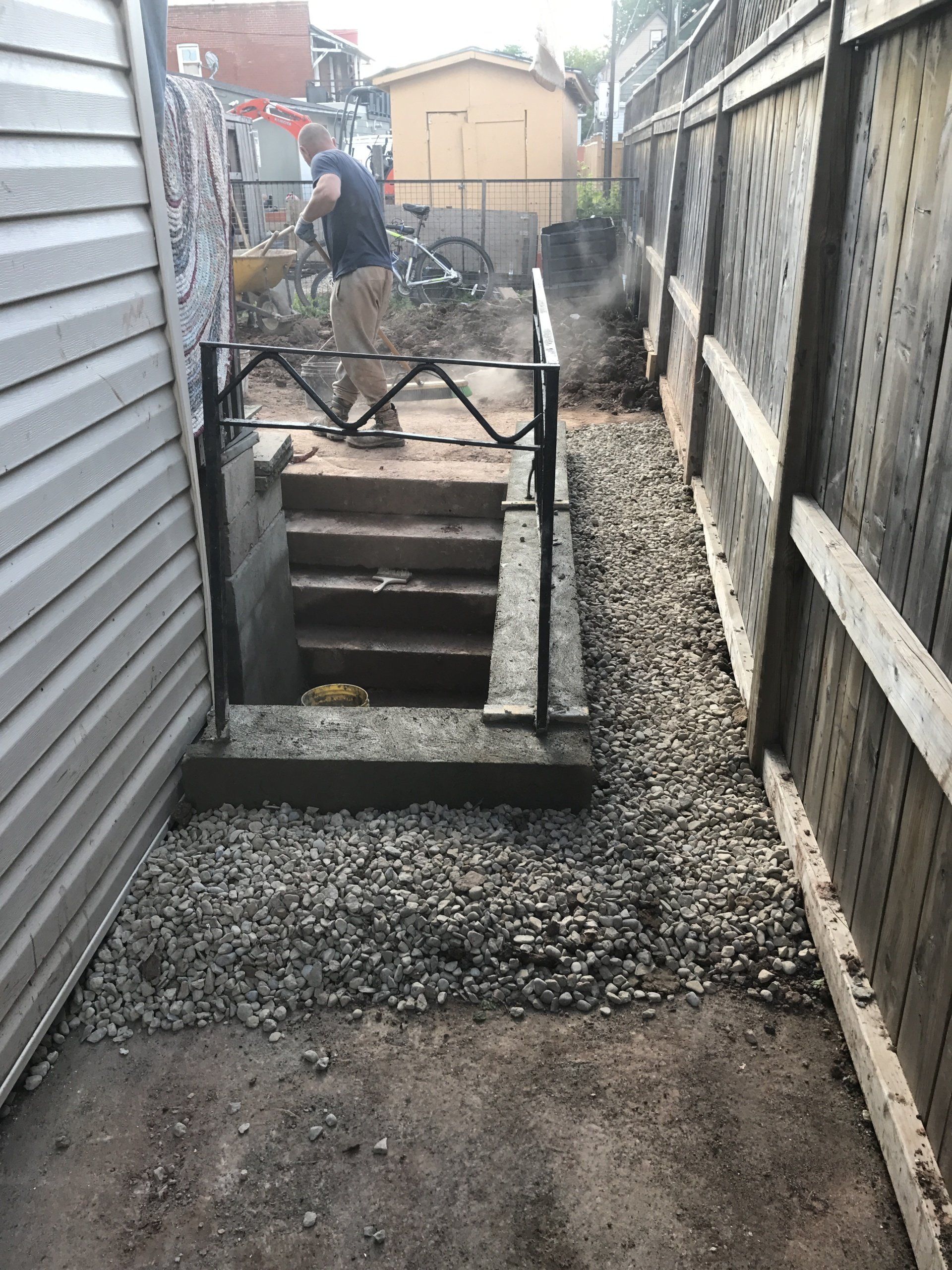 A man is standing next to a staircase in a basement.