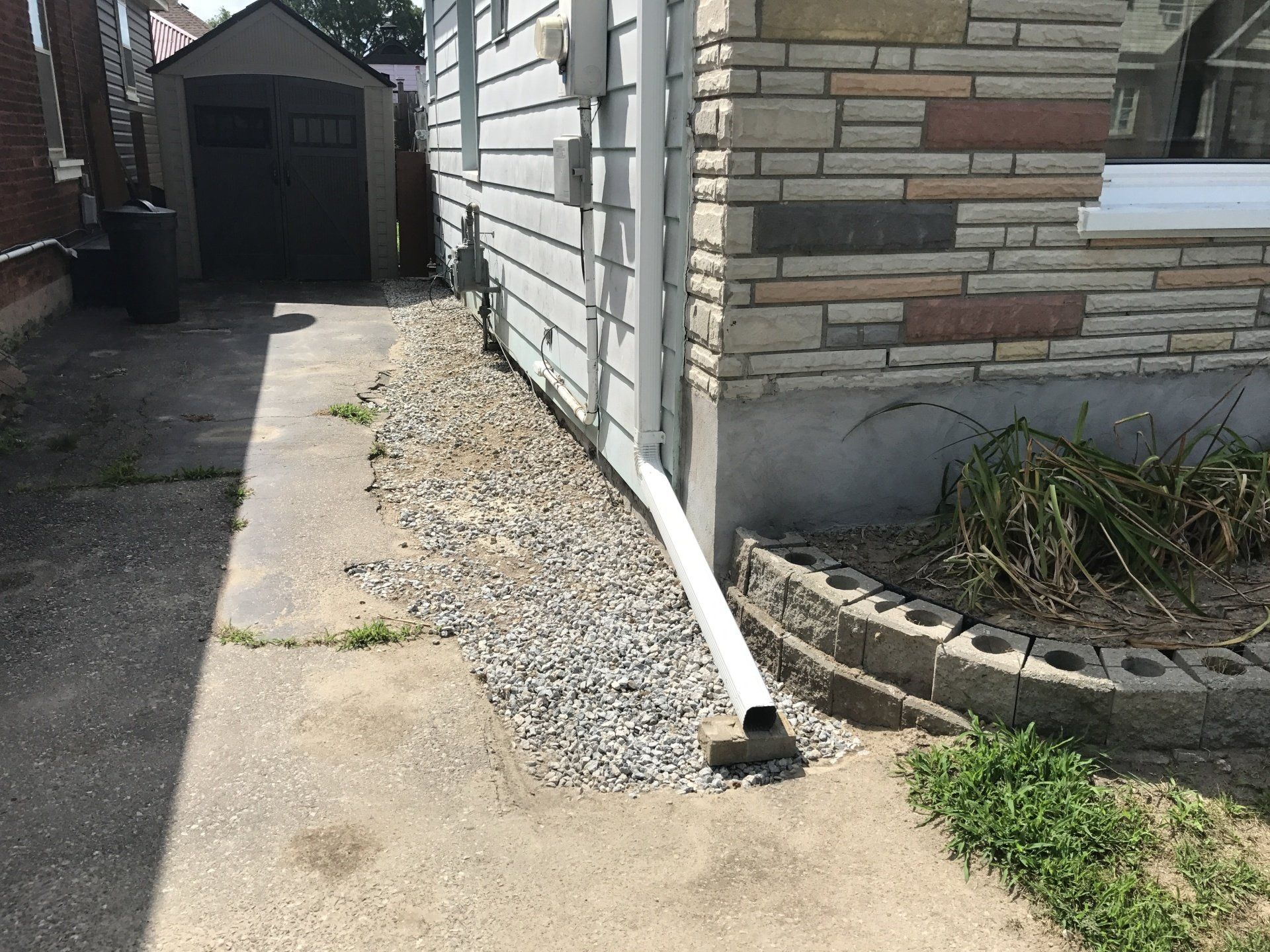 A white pipe is sitting on the side of a house.