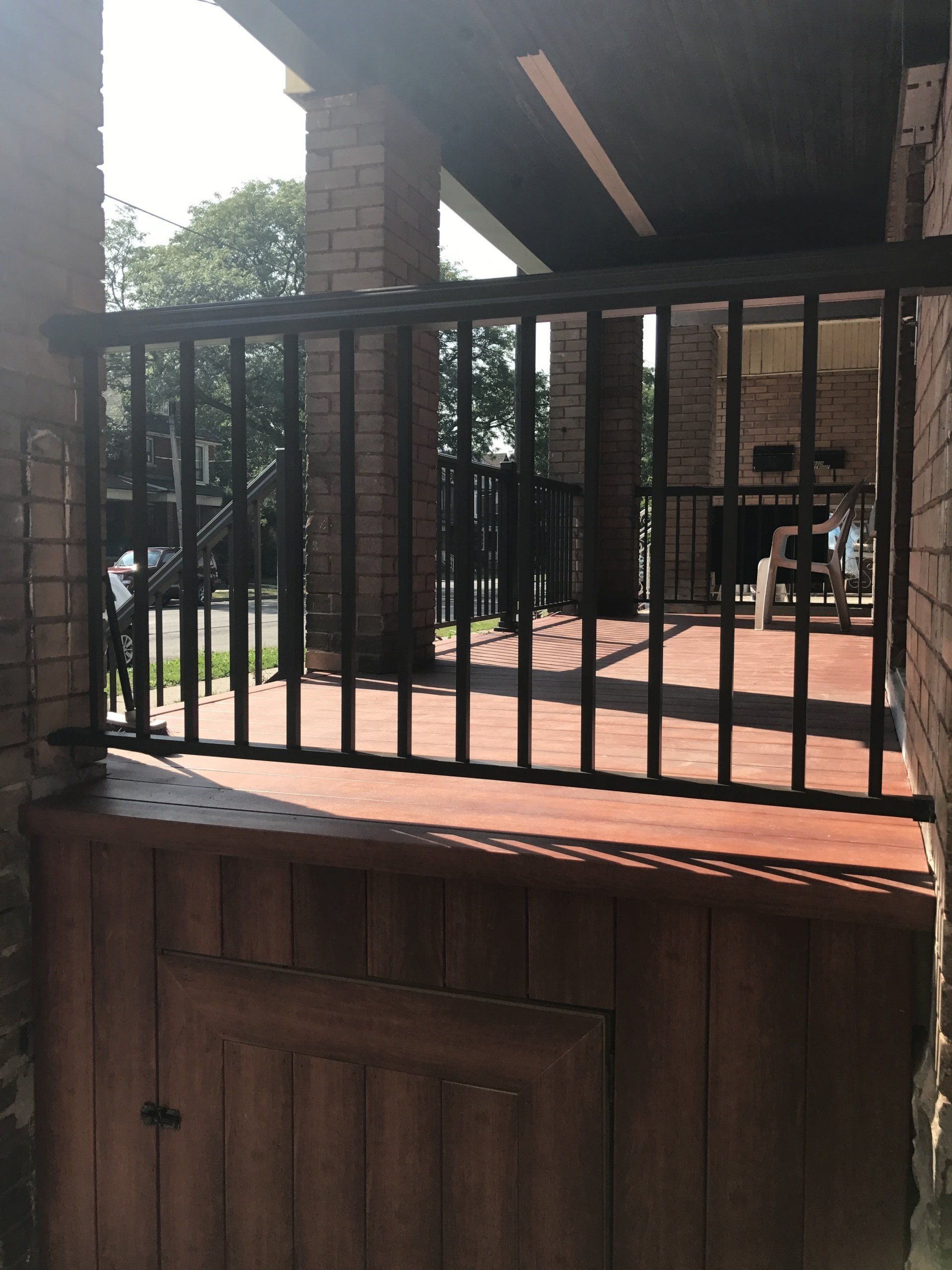 A brick building with a metal railing and a wooden door