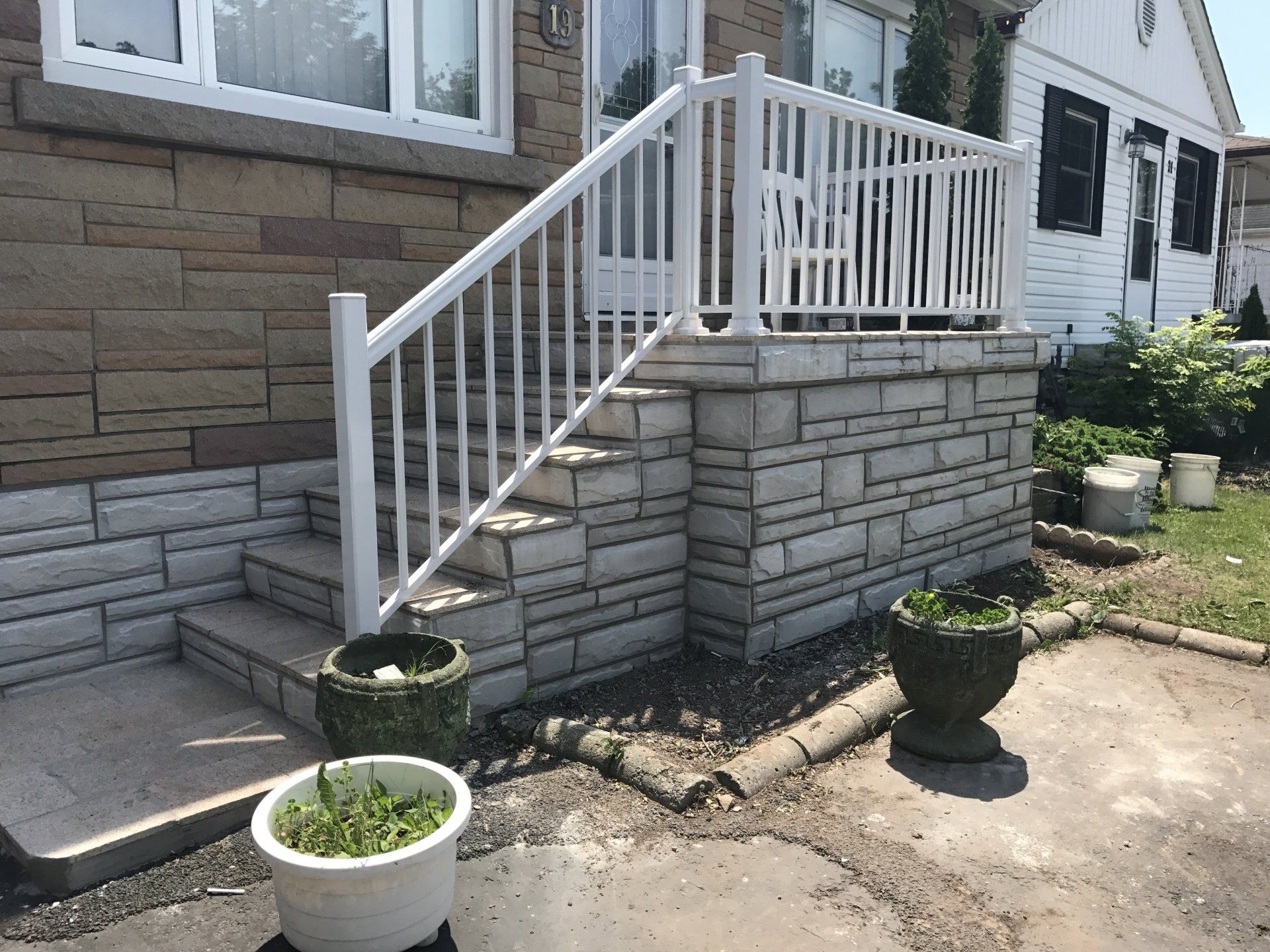 There is a white railing on the stairs of a house.