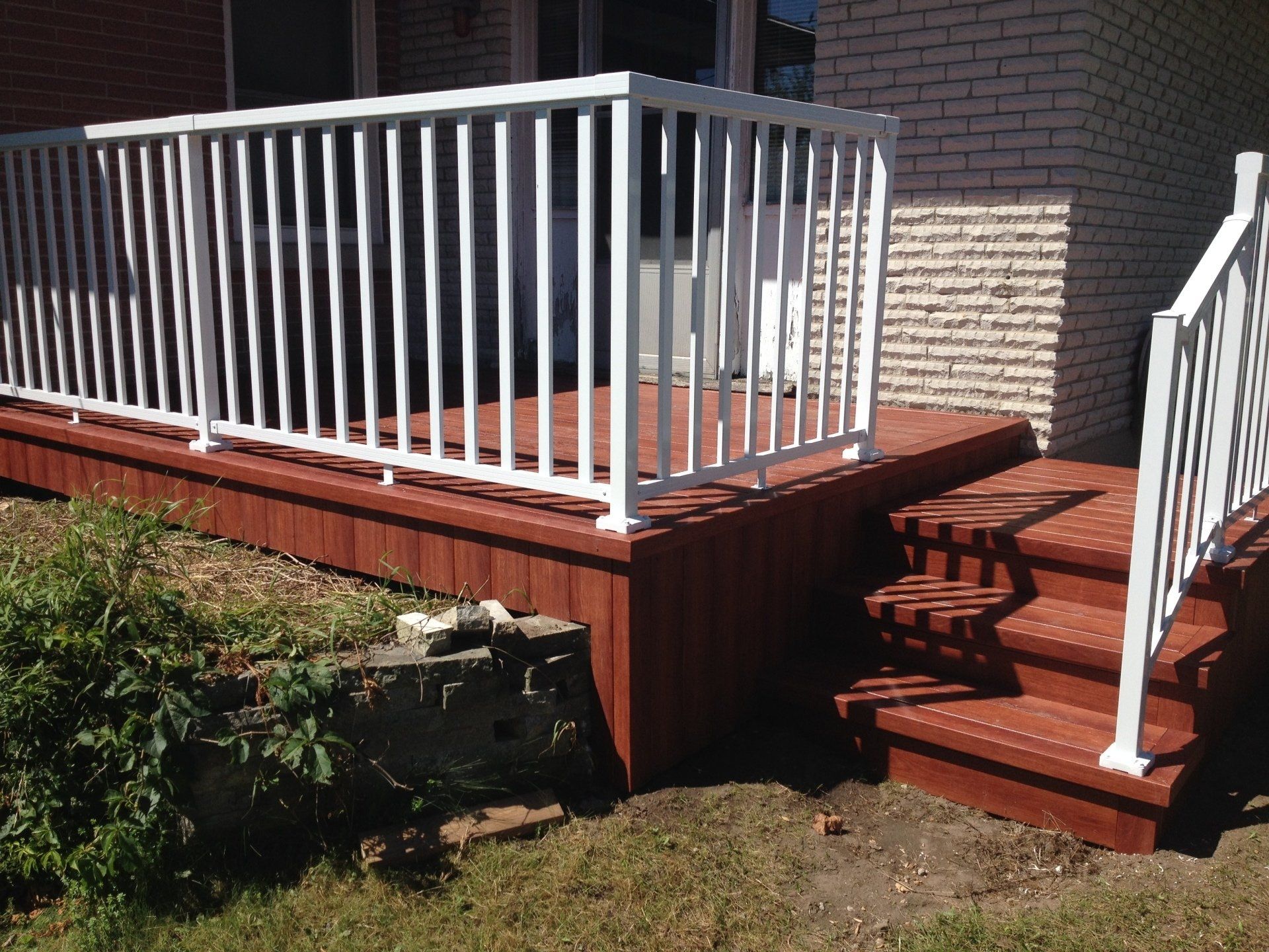 A wooden deck with stairs and a white railing