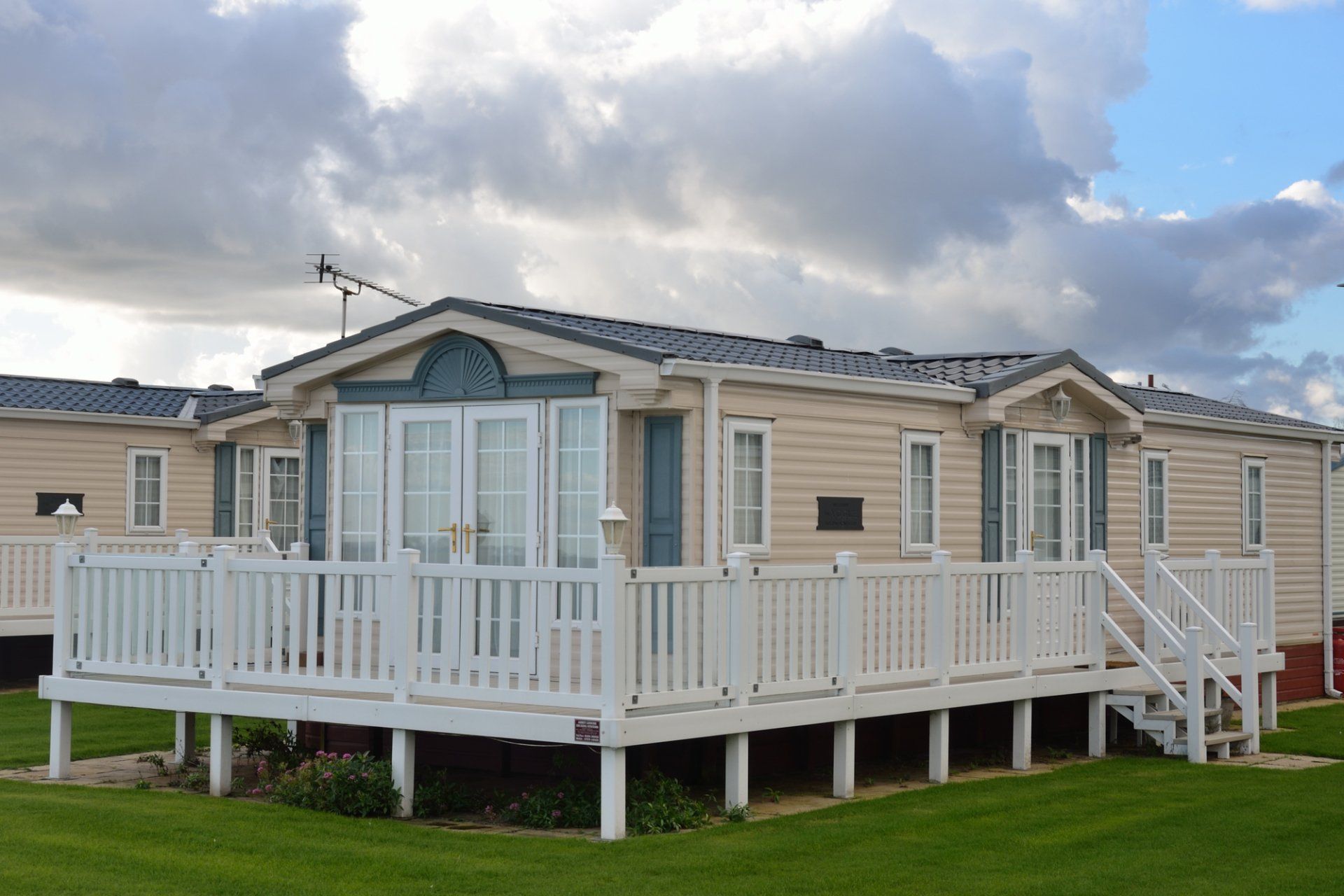 A mobile home with a large deck in front of it.