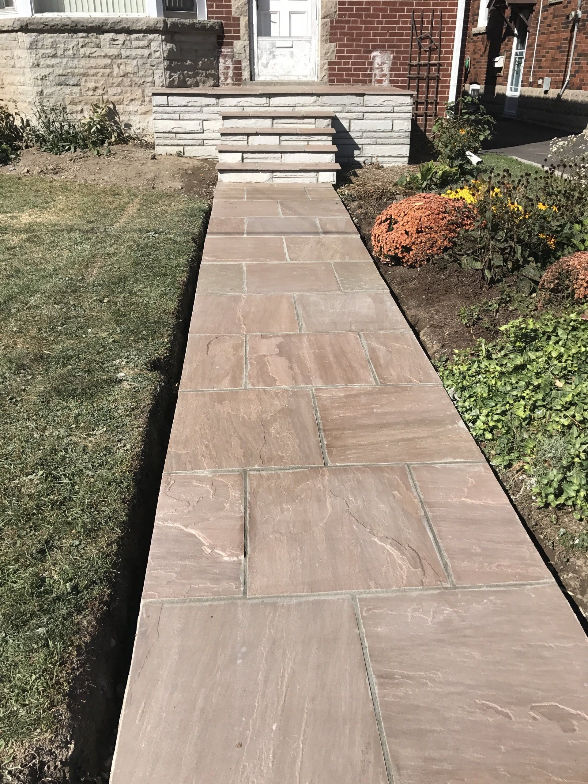 A stone walkway leading to the front door of a house.