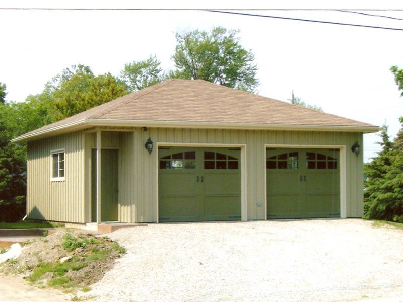 A garage with green doors and a brown roof