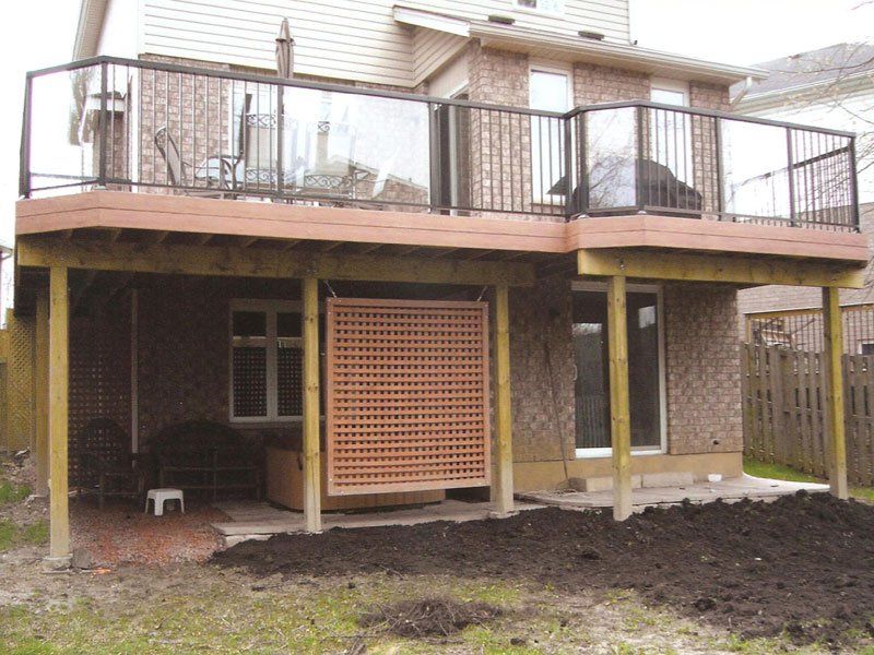 A house with a deck and a fence in the backyard